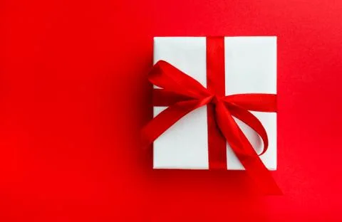 Small gift with red bow on red background. Stock Photos