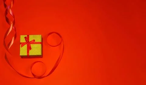 Small gift with red bow on red background. Free space for your text. Valentin Stock Photos