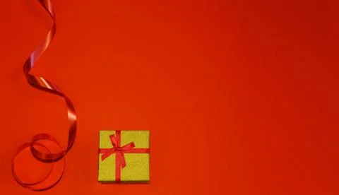 Small gift with red bow on red background. Free space for your text. Valentin Stock Photos