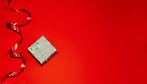 Small gift with red bow on red background. Space for your text Stock Photos