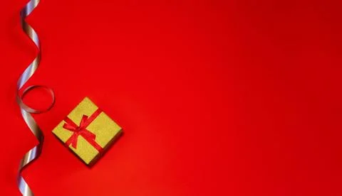 Small gift with red bow on red background. Free space for your text. Stock Photos