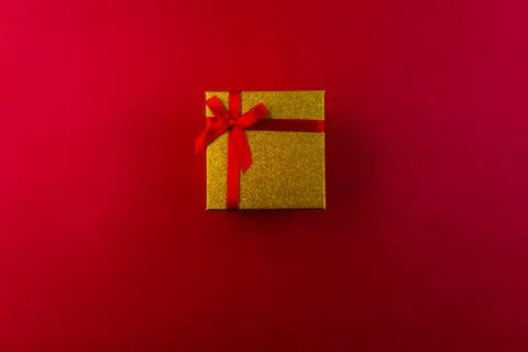 Small gift with red bow on red background. Free space for your text. Stock Photos