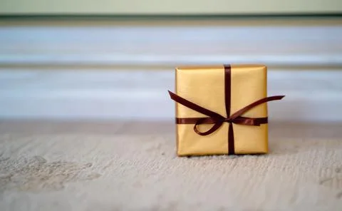 A small gift with a ribbon on the light background Stock Photos