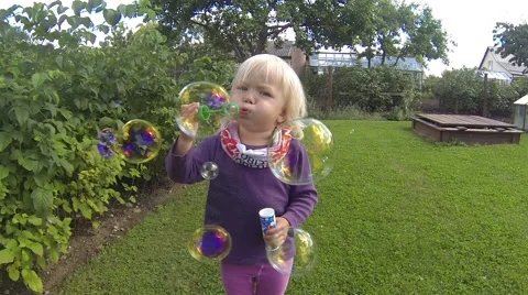 Small girl blowing bubbles Stock Footage 40970145