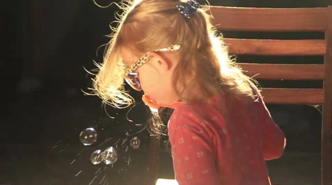 SMALL GIRL BLOWING BUBBLES Stock Footage 52594965