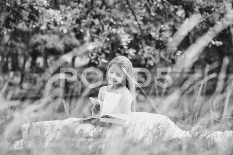 Small girl in dress with fruit basket and book Stock Photos