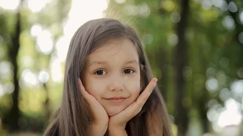 Small girl looking at camera on summer day. Young child 6-7 years thinking Stock Footage 265187760