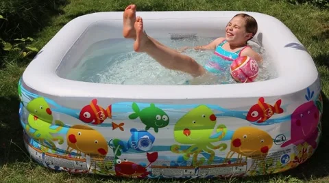 Small girl playing in the inflatable pool, summer time Stock Footage 51963217