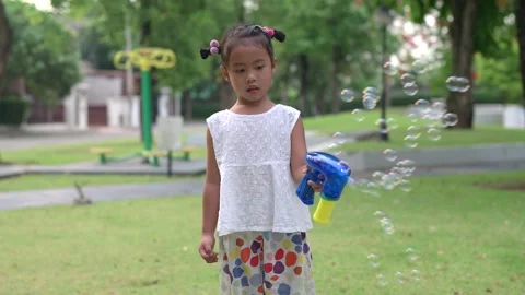 Small girl playing soap bubbles in garden. Vídeo Stock 190751772