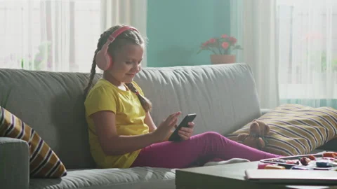 Small Girl Is Using Mobile Phone to Surf in the Internet Video stock 147735366