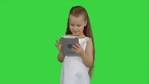 Small girl using tablet computer on a Green Screen, Chroma Key Stockbeeldmateriaal 78656580
