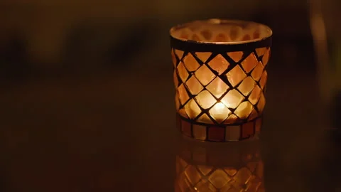 Small glass candle with a diamond pattern with flickering flame Stock Footage 269231223