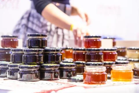 Small glass jars with jam or jam on the store counter. Stock Photos