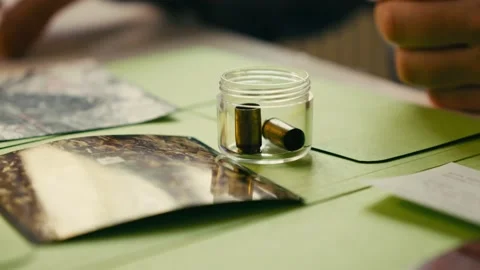 Small glass on the table into which detectives throw bullets from the Video stock 237444466
