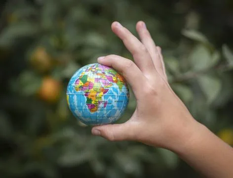 Small globe in a child's hand. Stock Photos