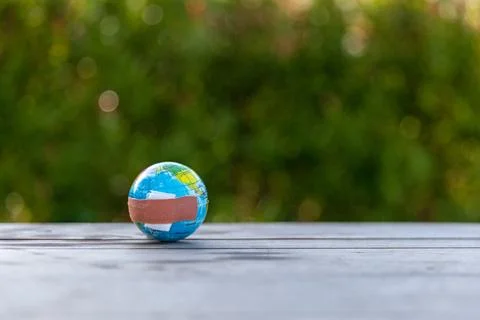 The small globe, earth is on hand, grass, leaf. The globe has maps on it an.. Stock Photos