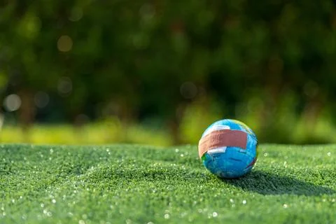 The small globe, earth is on hand, grass, leaf. The globe has maps on it an.. Stock Photos