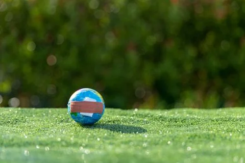 The small globe, earth is on hand, grass, leaf. The globe has maps on it an.. Stock Photos