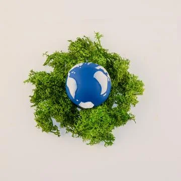 A small globe featuring blue oceans and white continents is nestled in vibr.. Stock Photos