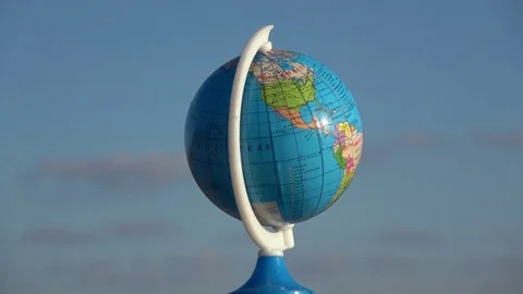 Small globe sphere map rotating on blue sky background, 4K Stock Footage 73540175
