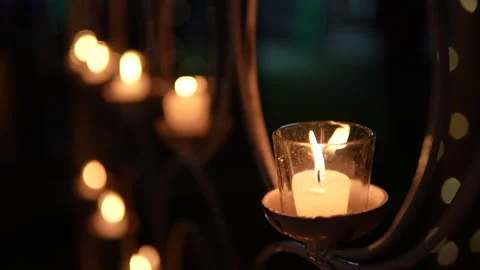 Small glowing candle held in a glass holder at night Stock Footage 335270769