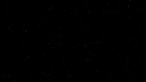 Small golden embers float against a pitch black background, creating a magical Stock Footage 340260092