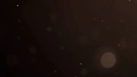 Small golden particles floating through a warm light beam Stock Footage 329598354