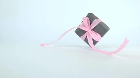 A small gray box with a pink bow. Isolated on white background. Stock Photos