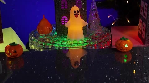 A small gray house surrounded by glowing ghost figures, rotates Stock Footage 346601647