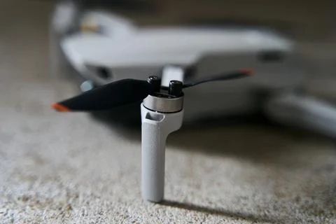 Small gray quadcopter on a gray background. Quadrocopter close-up. Stock Photos