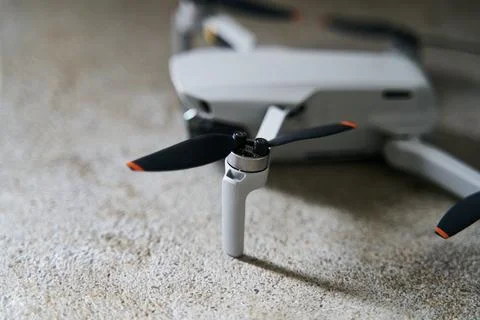 Small gray quadcopter on a gray background. Quadrocopter close-up. Stock Photos