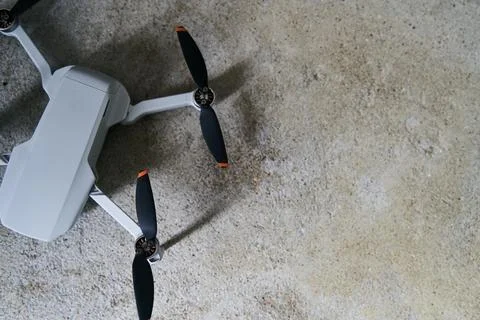 Small gray quadcopter on a gray background. Quadrocopter close-up. Stock Photos