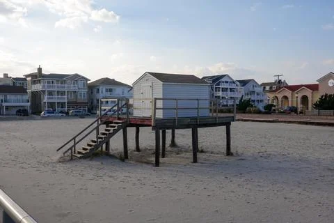A small gray shack a platform raised above the sand on a beach Stock Photos