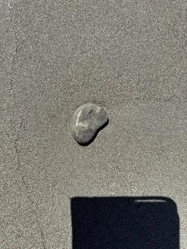 Small Gray Stone on a Textured Surface with a Rectangular Shadow Stock Photos