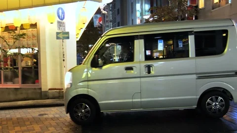 A small gray van moving on the streets in Tokyo Stock Footage 121259989