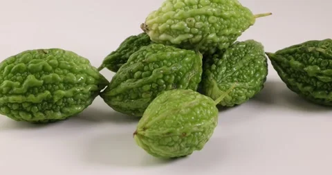 Small green bitter gourd vegetable fruit on white background bamboo basket Stock Footage 266212423