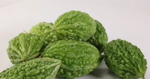 Small green bitter gourd vegetable fruit on white background bamboo basket Stock Footage 266212450