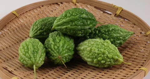 Small green bitter gourd vegetable fruit on white background bamboo basket Stock Footage 266212796