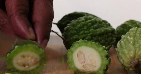 Small green bitter gourd vegetable knife fruit slicing on chopping board on.. Stock Footage 266212822