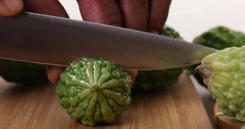 Small green bitter gourd vegetable knife fruit slicing on chopping board on.. Stock Footage 266212846