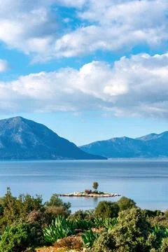 Small green house on a tiny island on the coast of Greece Stock Photos