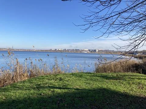 A small green meadow with access to the river and blue water Stock Photos