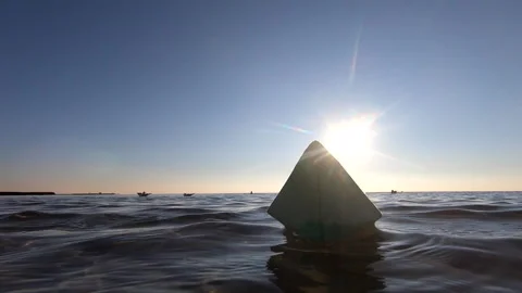 Small green paper boat floating on sea waves, sunny day. Bottom view, close-up. Stock Footage 221194656
