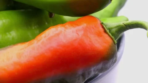 Small green peppers rotating in deep plate on white background 스톡 동영상 344052962