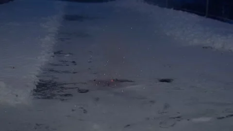 Small ground firework exploding on snow at night Video stock 327429985