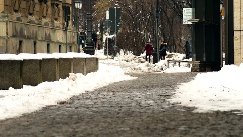 A small group of anonymous people walking on a snow-covered road. Stock Footage 109385329