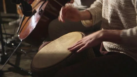 Small group of musicians play cello and percussion drums with hands Stock Footage 253395117