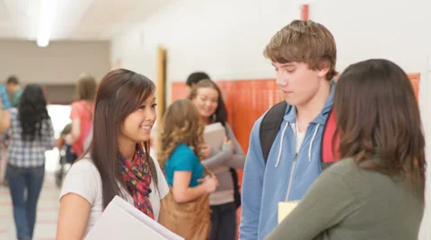 A small group of students stand in a high school hallway and talk to each other Stock Footage 33891682