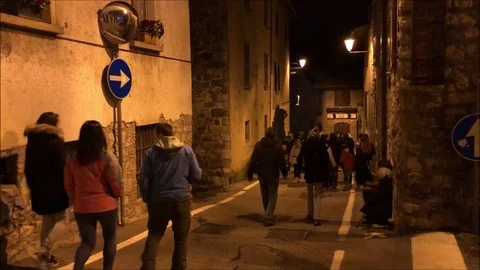 Small groups of people walking in a small town in italy by night Stock Footage 101626372