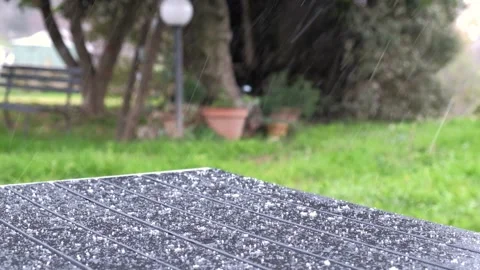 Small hailstones fall on the table on the patio in winter season. Video stock 296057399